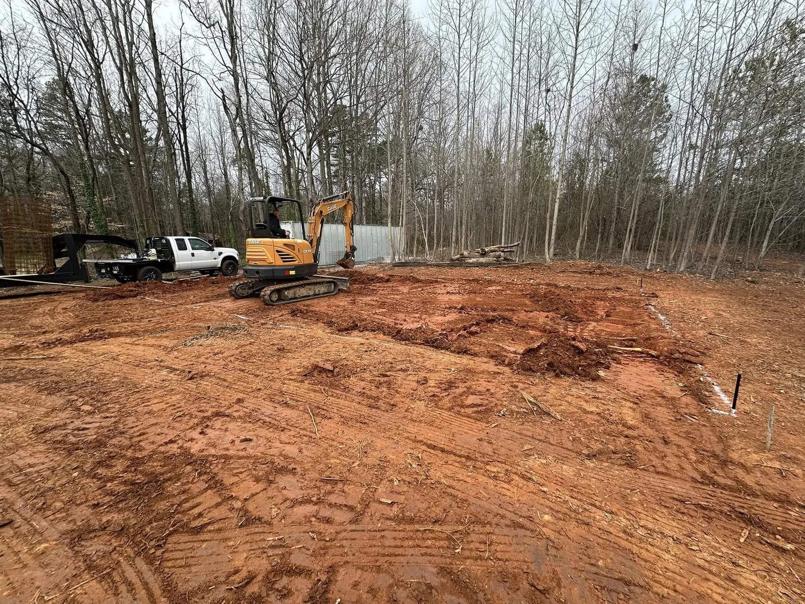 Excavator and truck finishing a cleared lot