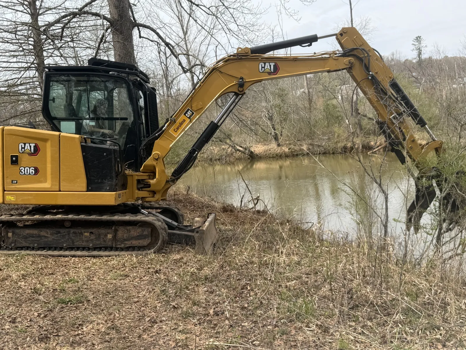 Excavator working at the edge of a pond